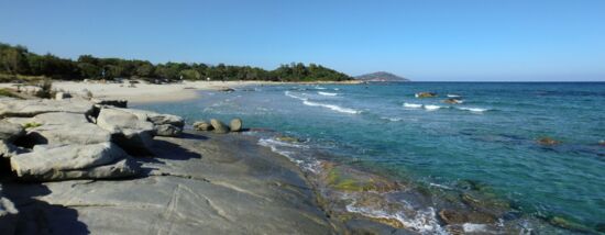 Blick über eine Strandbucht, im Hintergrund die Felsküste südlich von Arbatax